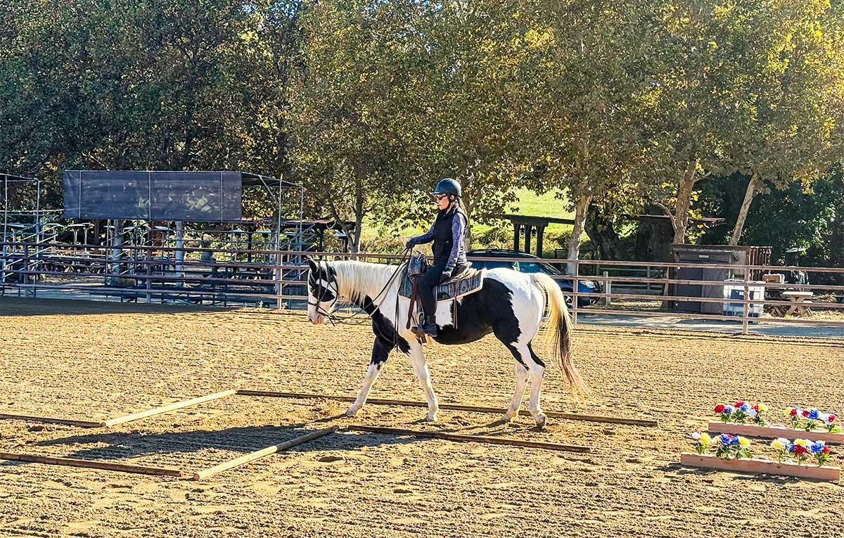 woman riding a paint horse through an L-corner at Alisal Ranch, California